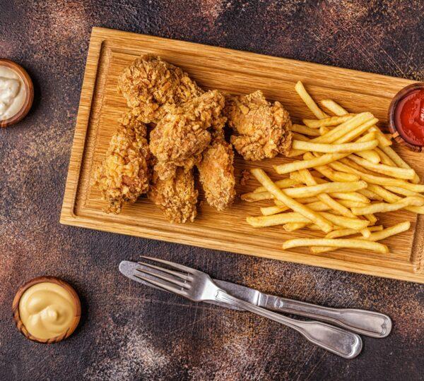 Fried chicken wings with french fries.